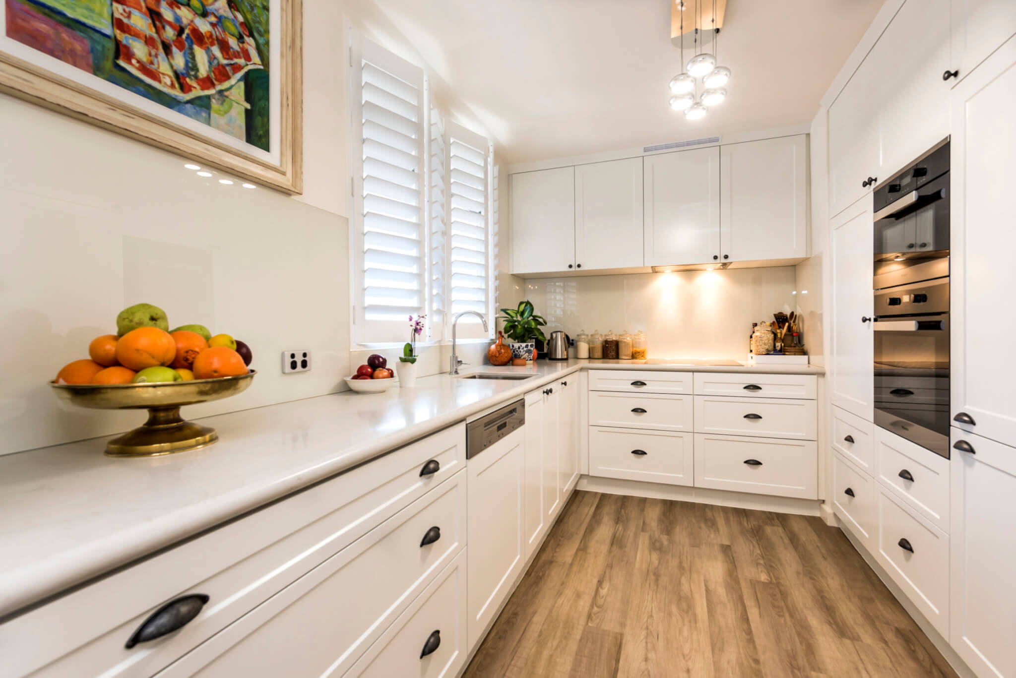 White kitchen with white cupboard finishes and light brown floors